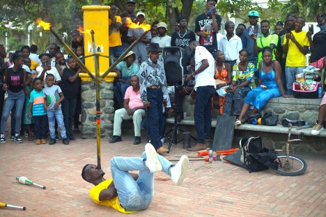 Circus performer Davideson Desamours holding a giant tripod with three lit torches under his nose during the first edition of Sikannou at Place d’Armes in Cap-Haïtien on April 19, 2026. Photo by Onz Chéry/ The Haitian Times